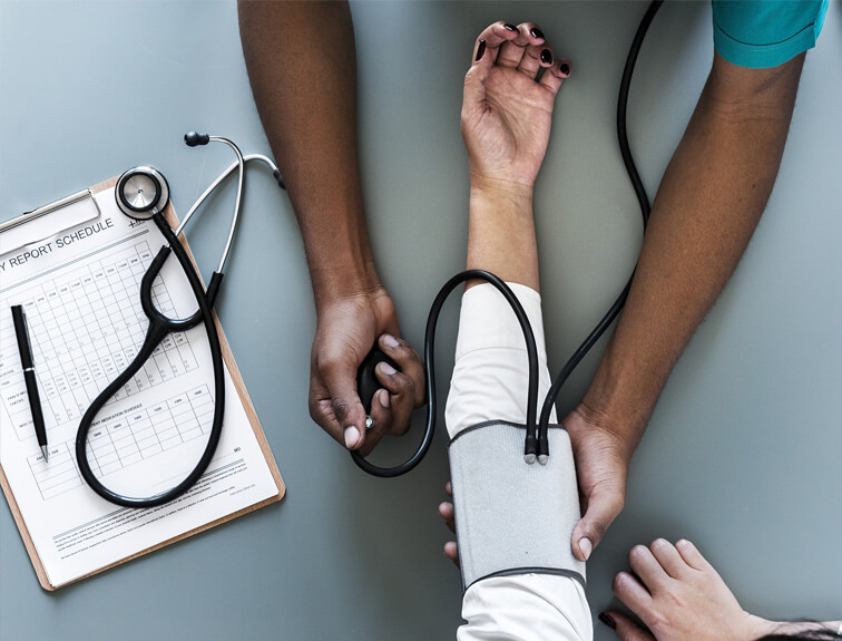 Medical Assistant taking blood pressure on a patient.