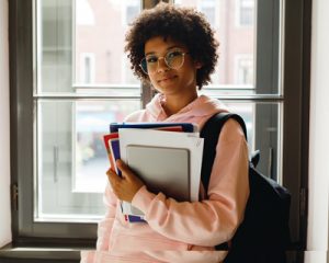 Student carrying books transfering college credits.