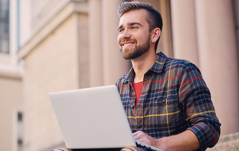 Image of a man on a laptop taking technical school classes.