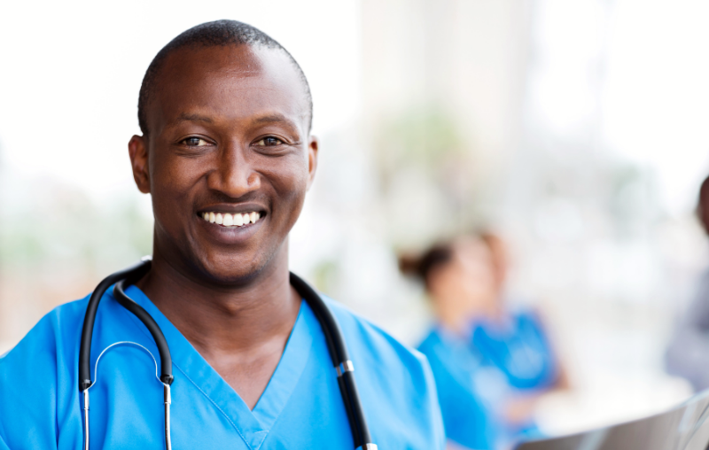 african american male smiling while wearing scrubs and his stethoscope