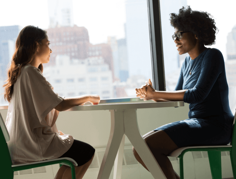 Image of two women sitting across from each other in an interview